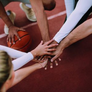 Overhead view of basketball team holding hands over court