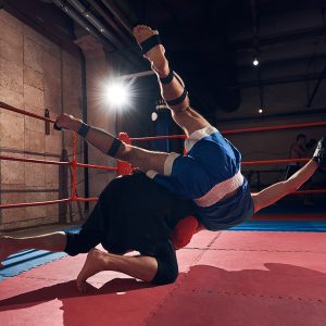 aggressive man boxer training mma with his trainer, fighting in the ring at the health club