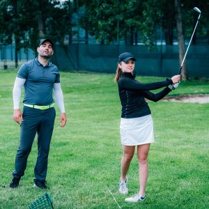 Learning golf. Golf instructor with young women on a golf course